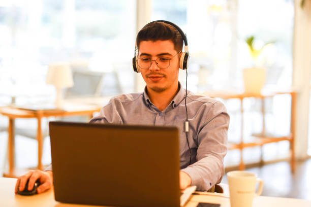 istock young man working remotely hybrid with laptop in cafe 1460884919
