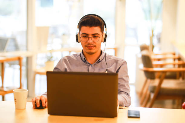 istock young man working remotely hybrid with laptop in cafe 1460884964