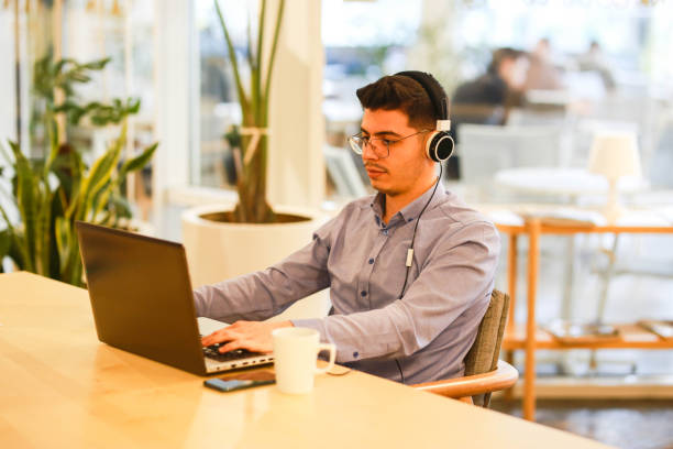 istock young man working remotely hybrid with laptop in cafe 1460885061