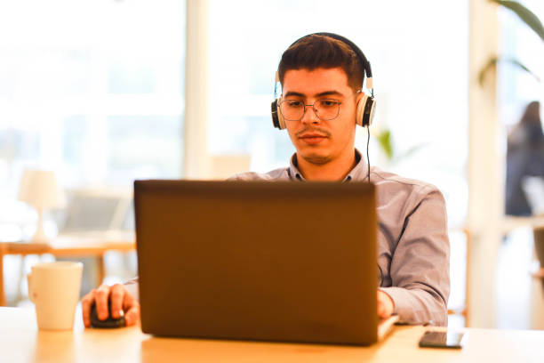 istock young man working remotely hybrid with laptop in cafe 1460885086