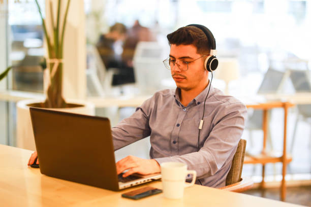 istock young man working remotely hybrid with laptop in cafe 1460885107