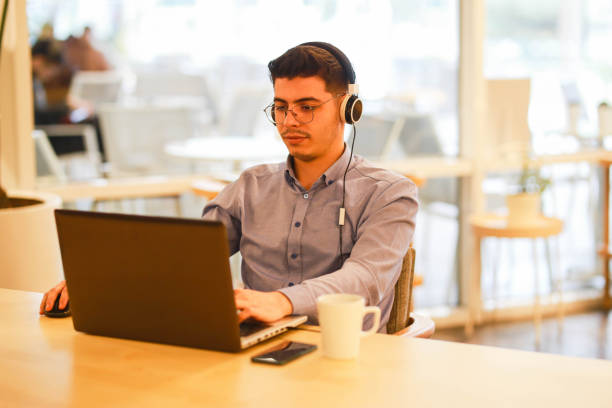istock young man working remotely hybrid with laptop in cafe 1460885179