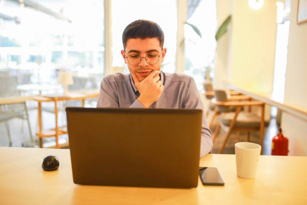 istock young man working remotely hybrid with laptop in cafe 1460885318