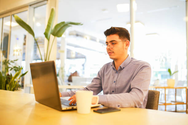 istock young man working remotely hybrid with laptop in cafe 1460885713