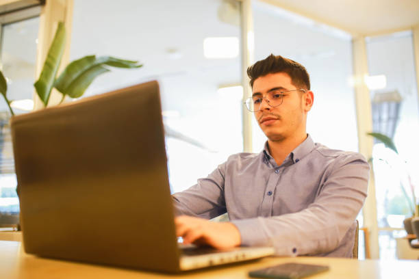 istock young man working remotely hybrid with laptop in cafe 1460885875