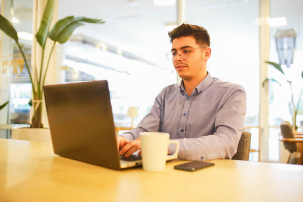 istock young man working remotely hybrid with laptop in cafe 1460885939