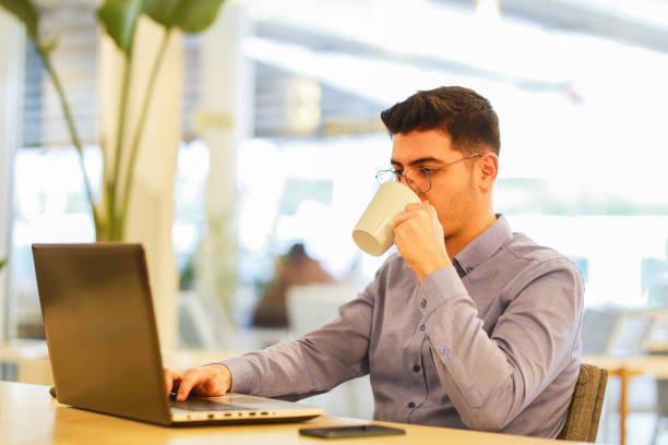 istock young man working remotely hybrid with laptop in cafe 1460885968