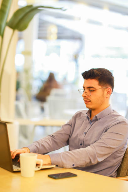 istock young man working remotely hybrid with laptop in cafe 1460885969