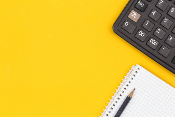 istock Calculator, coffee cup and on a yellow background, flat lay. 1460886106