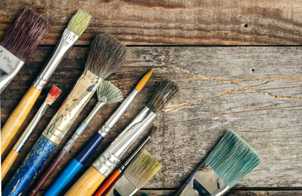 istock Paint brushes of different sizes on a wooden background, flat lay. 1460887212