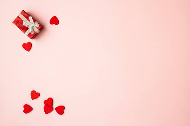 istock Red gift box on pink background with red hearts. Holiday web banner. Top view. 1460887959