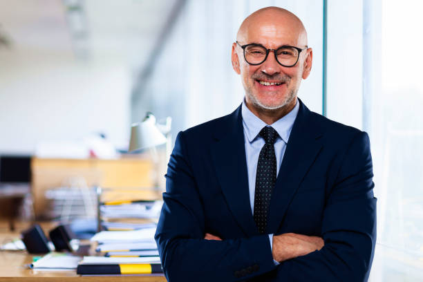 istock Happy businessman wearing suit and tie while standing at the office 1460898678
