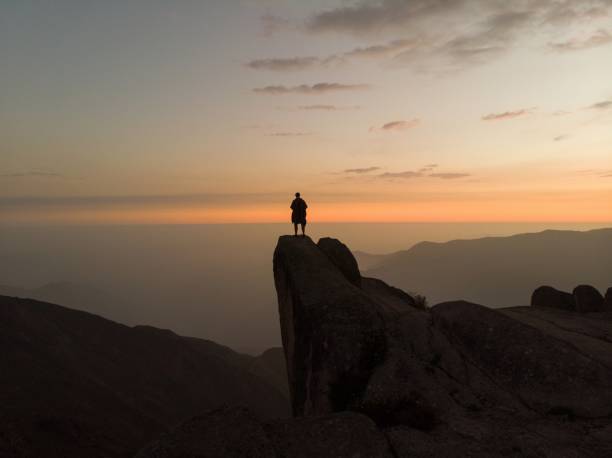 pôr do sol panorama caminhante poncho em marcahuasi andes planalto formações rochosas montanha colina vale paisagem natureza lima peru - the stone forest - fotografias e filmes do acervo