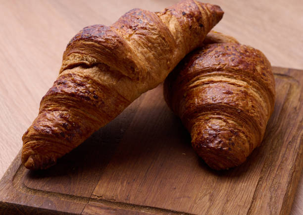 istock Baked crispy croissant on a wooden board, breakfast 1460901558