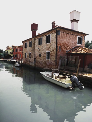 Old rustic mediterranean brick house building with boat on main canal of Torcello Island Venetian Lagoon Venice Veneto Italy Europe
