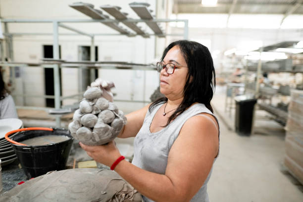 istock Mature woman sculptor creates a clay sculpture at workshop 1460906277