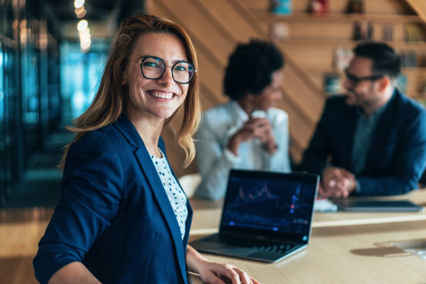 Portrait of crypto trader at the office Portrait of crypto trader at the office. Successful female trader in formalwear working in office, looking at camera in front of laptop screen, checking global currency index on fund exchange. Trading stock or cryptocurrencies. Trading app on screen. woman trading stocks stock pictures, royalty-free photos & images