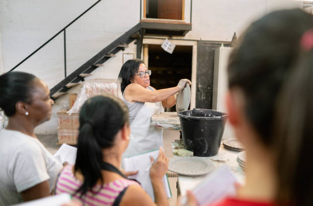 istock Woman giving a demonstration to workers in a ceramics workshop 1460907648