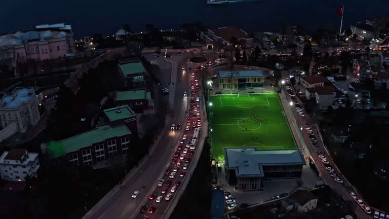 AERIAL Illuminated football field in the city center in the evening