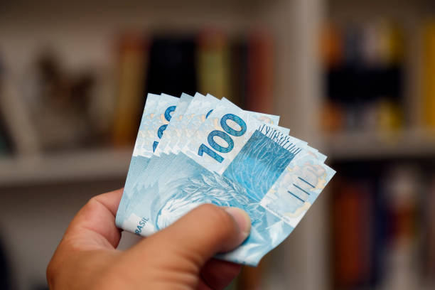 istock banknotes of one hundred reais folded in the hands 1460910037