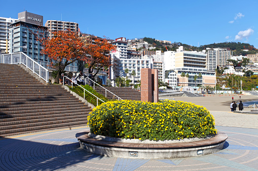 Moon Terrace at Atami Water Park in Atami City, Shizuoka Prefecture, Japan with Sun Beach and apartments and hotels in the background and some people walking around.