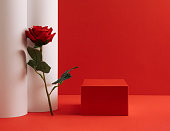 Suitable for Product Display and Business Concept. Modern aesthetic. Product podium and fresh rose flower on red  background. Elegant beauty concept.