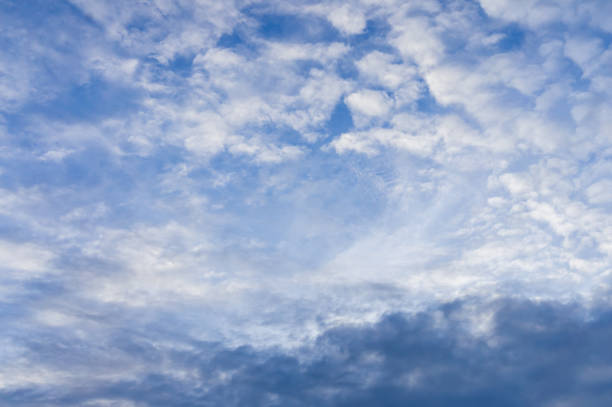A mixture of white fluffy and puffy clouds against the blue sky in the upper half of the photo and beginning to form cumulus clouds in the lower part of the photo