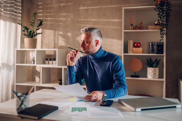 istock Gray haired middle aged man working in a home office 1460924889