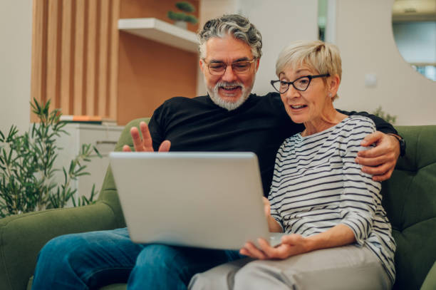 istock Senior couple using laptop while sitting on a couch at home 1460924946
