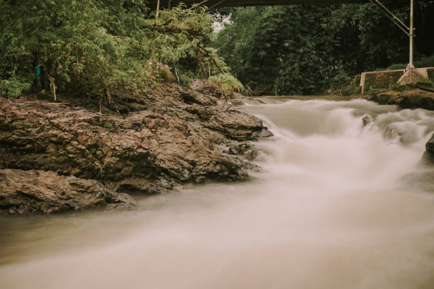 picture of a river with swift water flow and pillow lava  rocks in Yogyakarta, Indonesia, long exposure shot.