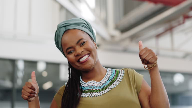 Black woman, thumbs up and smile at work with pride for African culture, tradition and heritage while walking with positive mindset. Portrait of female employee with happiness and approval of success