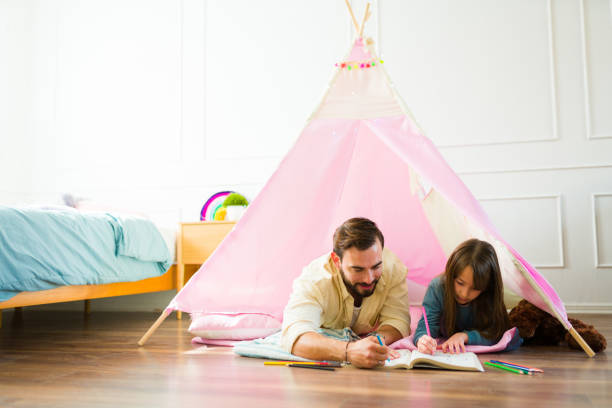 istock Dad and little girl playing coloring a book 1460932752