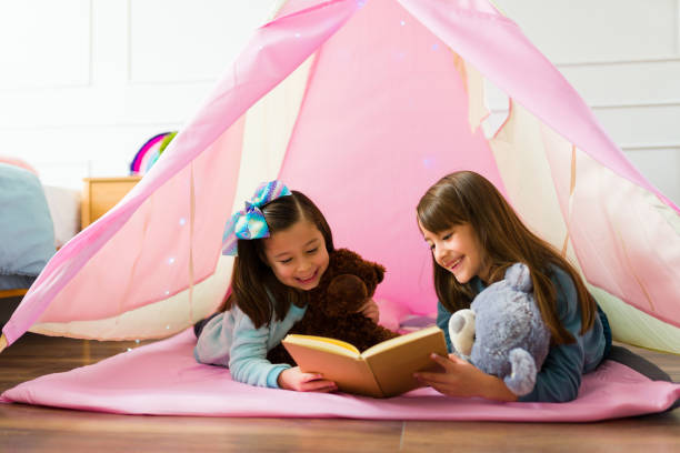istock Cheerful little girls reading a book together 1460934549