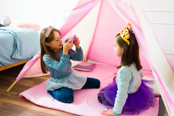 istock Best friends princesses playing with a toy camera 1460935368