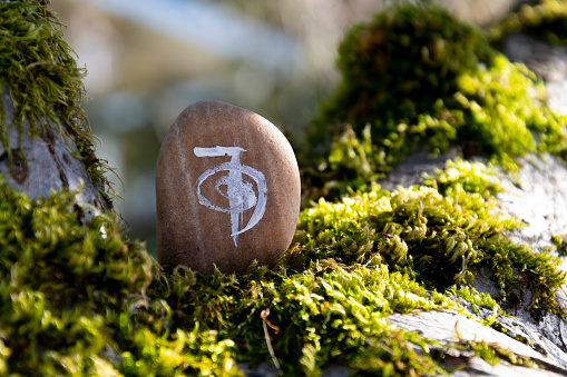 A close up image of a healing reiki symbol written on a sacred stone.
