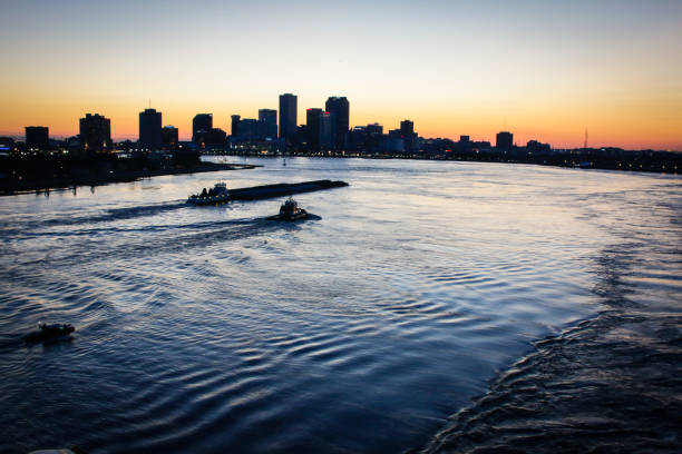 Boats traveling on the Mississippi River in New Orleans, Louisiana during sunset.