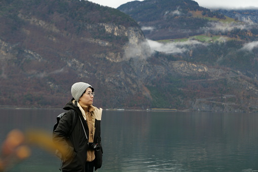 An Asian traveler with lake and mountain view in winter