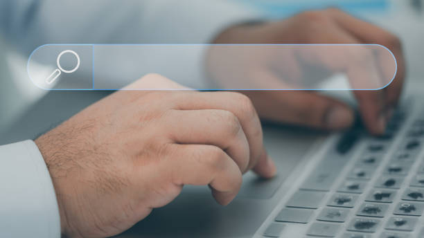 istock Hand working with computer laptop on desk with icon of searching browsing internet data information with blank search bar. 1460939929