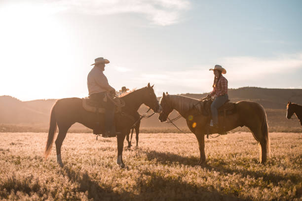istock Husband and Wife Silhouette Horseback Riding 1460945340