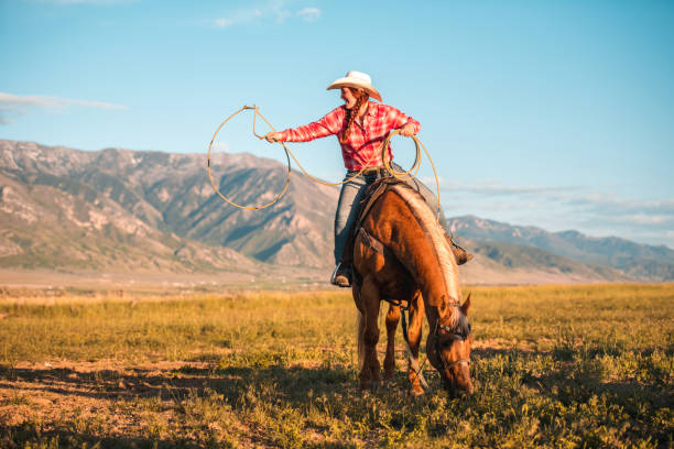 istock Young Woman Twirling a Lasso while Riding a Horse 1460945364