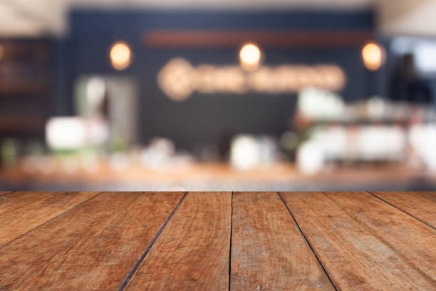 istock Perspective brown wood on blur cafe with light bulb background 1460949268