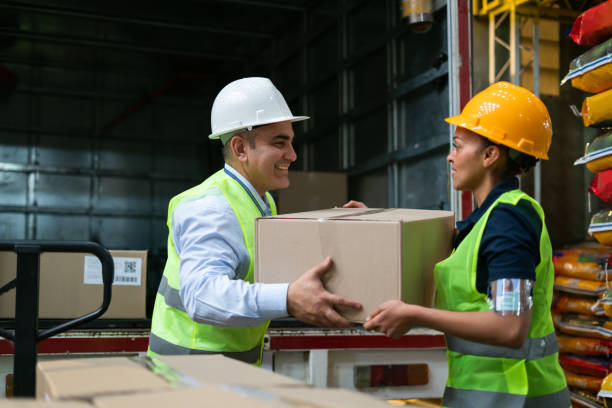 istock Team of workers at a distribution warehouse loading a truck with boxes 1460953897