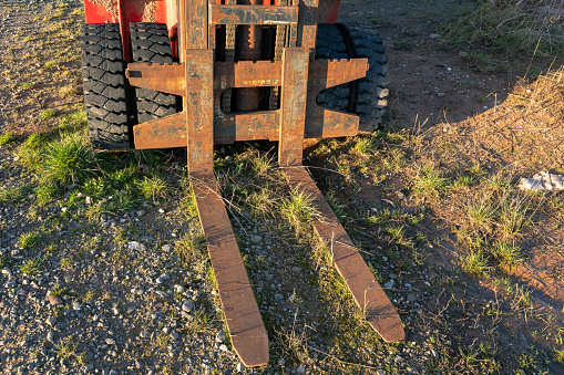 Huge rusted fork from a old forklift on the stony ground