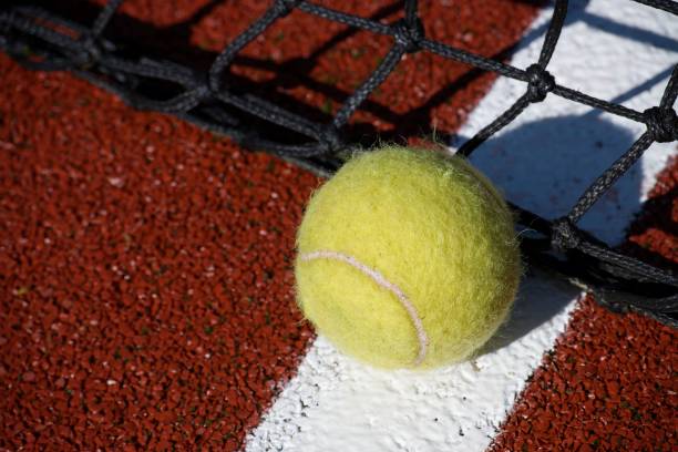 istock Tennis scene with black net, ball on white line 1460957943