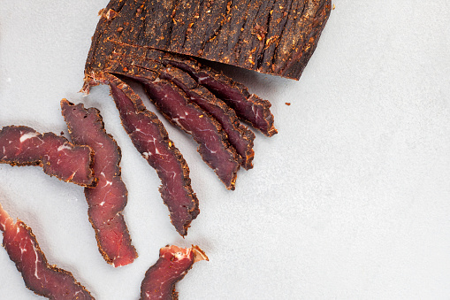 Freshly cut South African biltong on light background with selective focus and copy space.