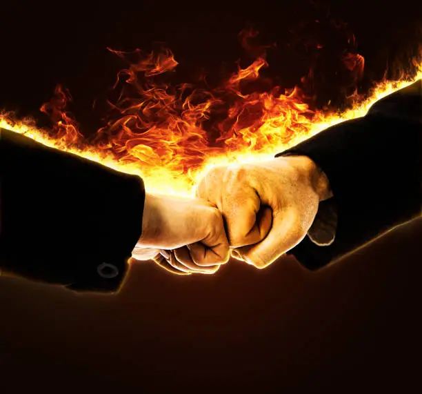 Photo of Fiery fist bump: business man and woman bumping fists in the modern greeting