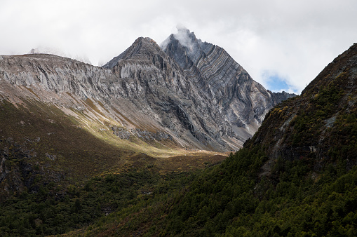 A rock mountain in Yading, Daochen, China. It appeared just after wind blew the fog away.