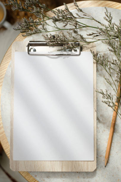 istock mockup blank clip paper board top view on stone round table with sunlight 1460978870