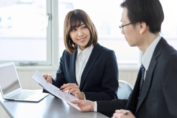 Asian business woman smiling and checking documents Asian business woman smiling and checking documents subordination stock pictures, royalty-free photos & images
