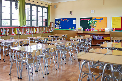 Neatly arranged desks with four chairs each, cubbyholes for each student’s books and projects, and decorated bulletin boards.